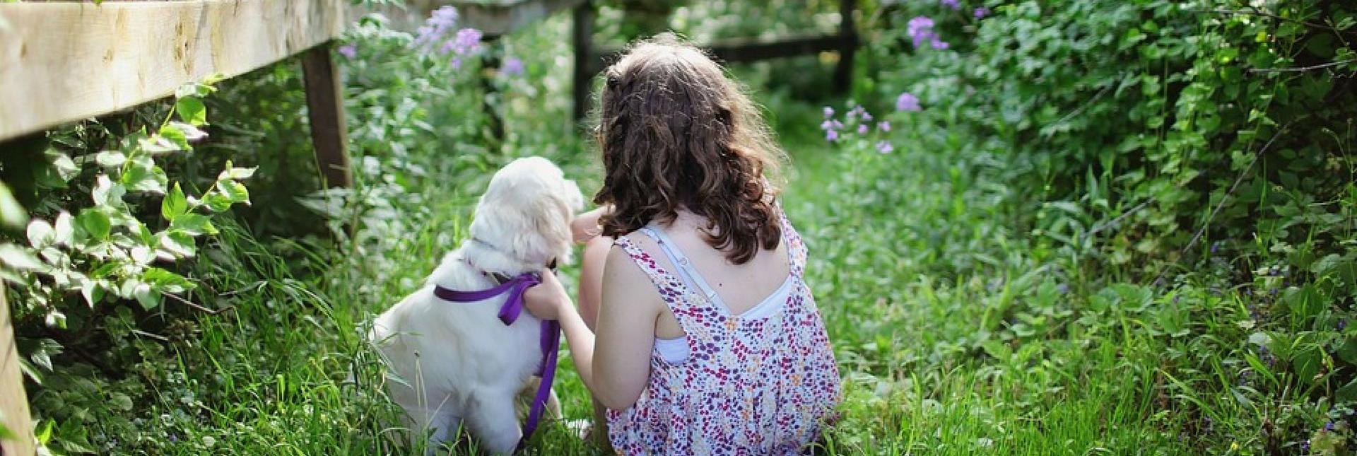 Ein Mädchen und ein Hund in einem Garten